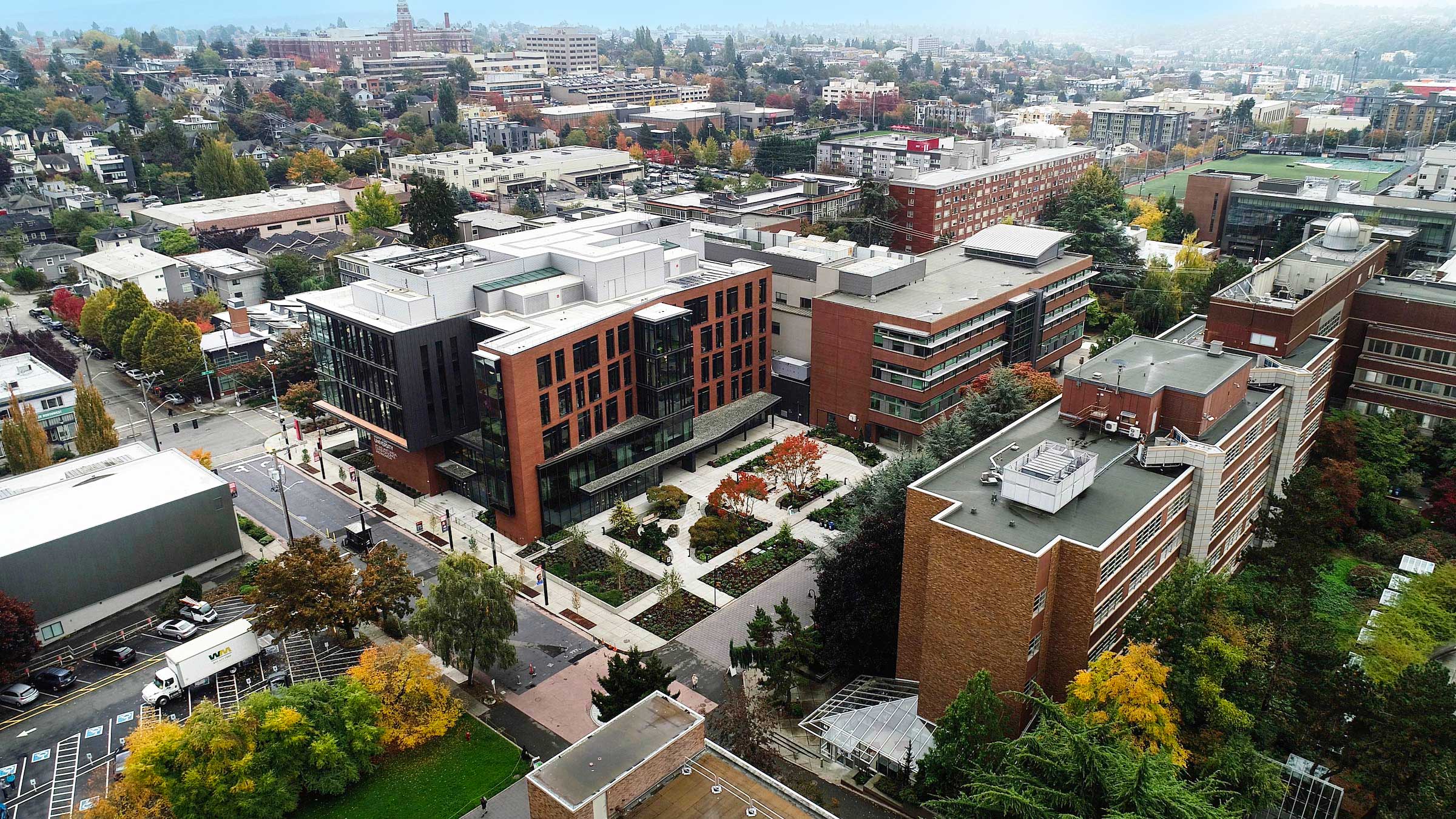 An aerial view of Seattle University's campus featuring the new Sinegal Center building and the neighborhoods beyond.