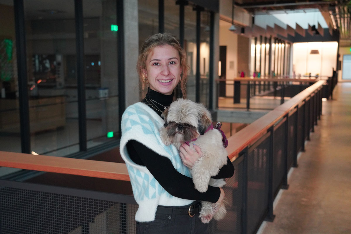Marrakech Maxwell, ’22, poses for a portrait with her dog in her arms, inside the new Sinegal Center building.