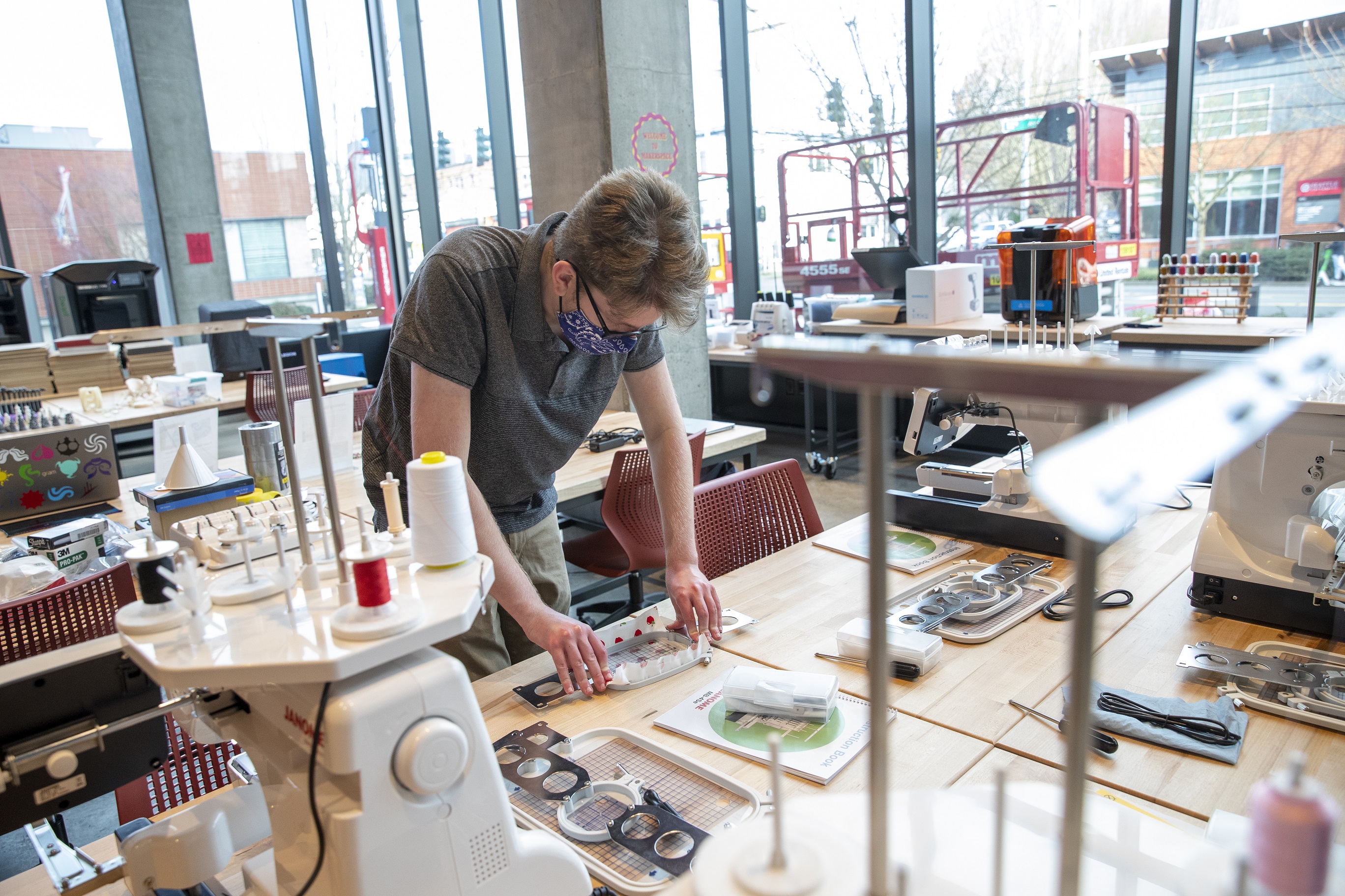 Male student standing at a work table in the makerspace