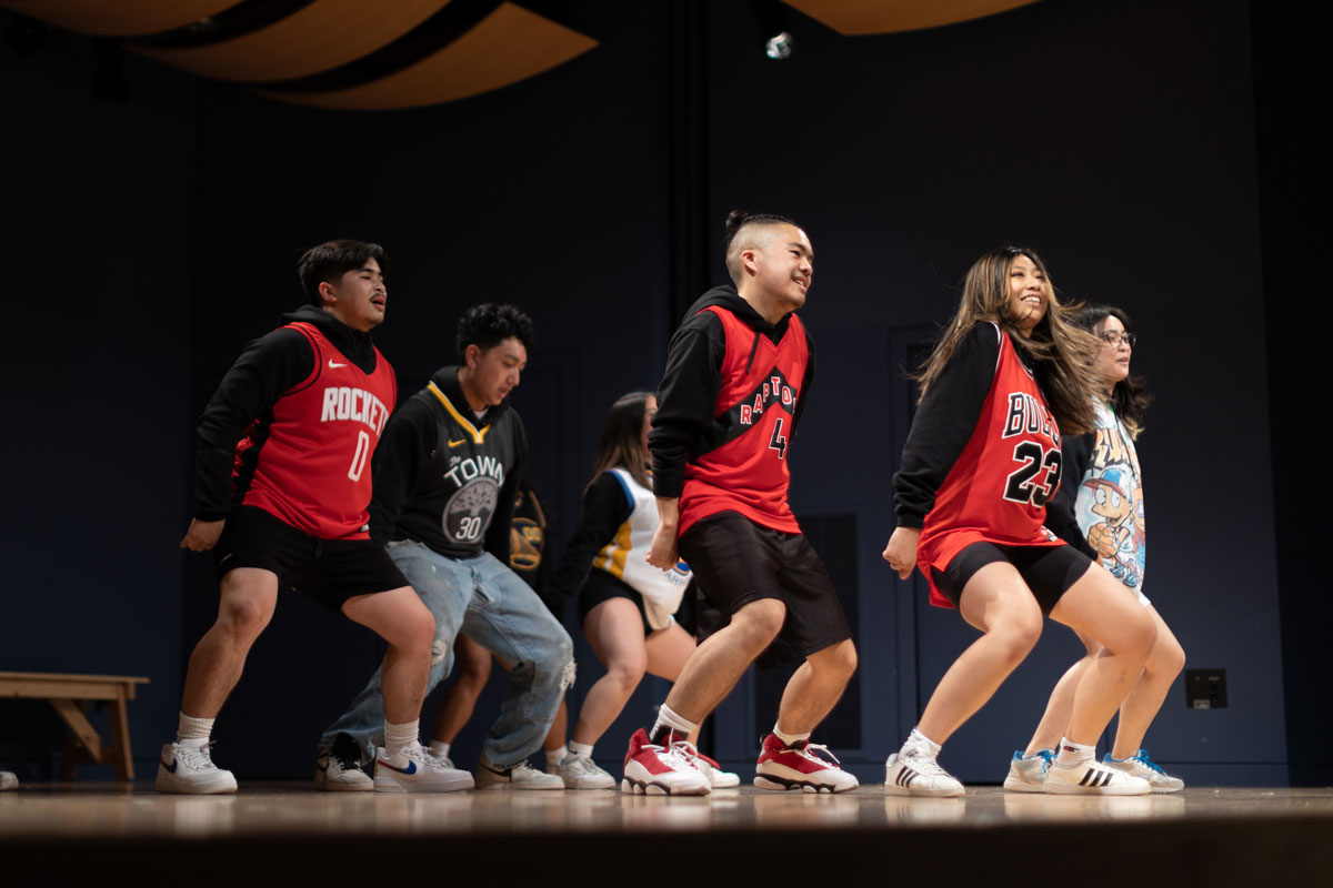 A group of Filipino students synchronized on a stage in the middle of a street dance performance